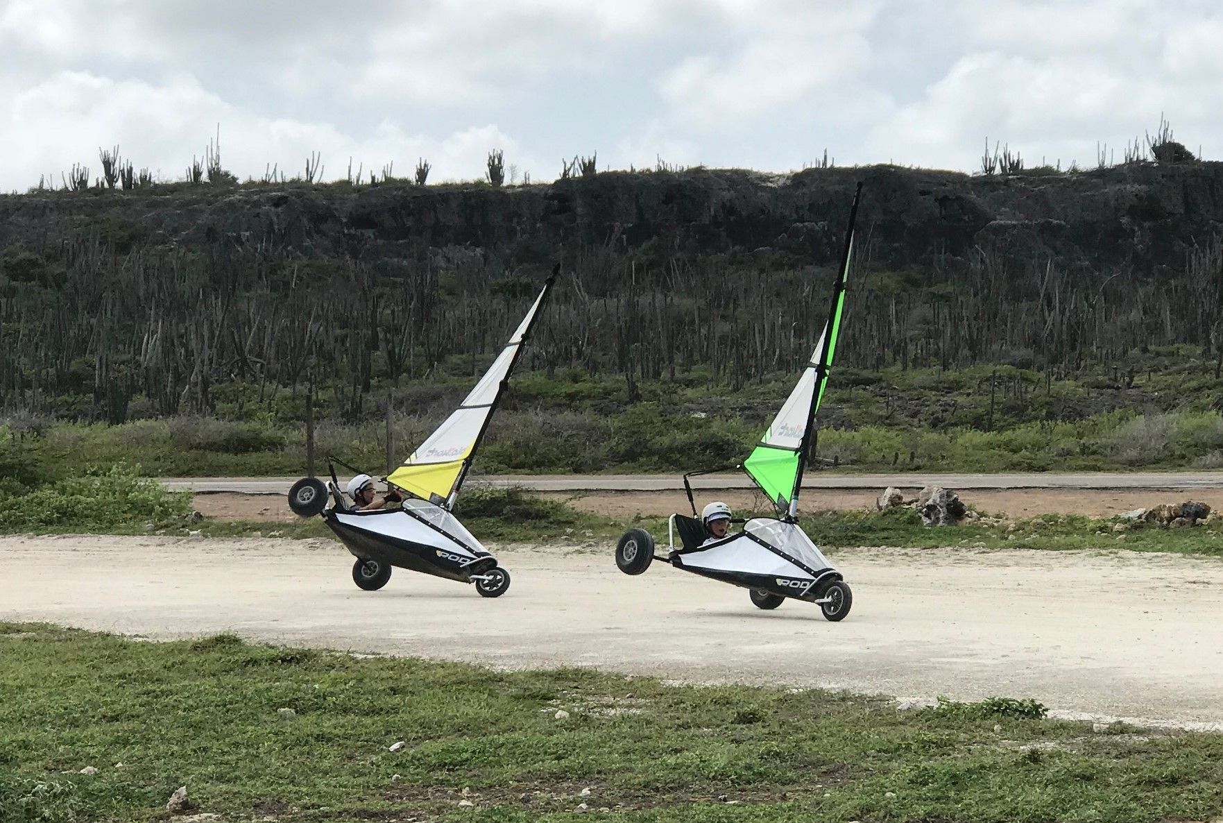Two blokarts sailing side by side below the hills