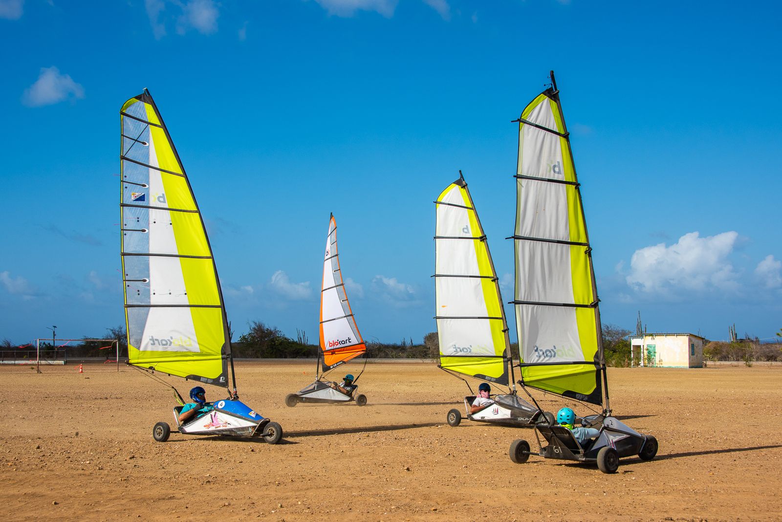 Three blokarts rigged on the field under a blue sky
