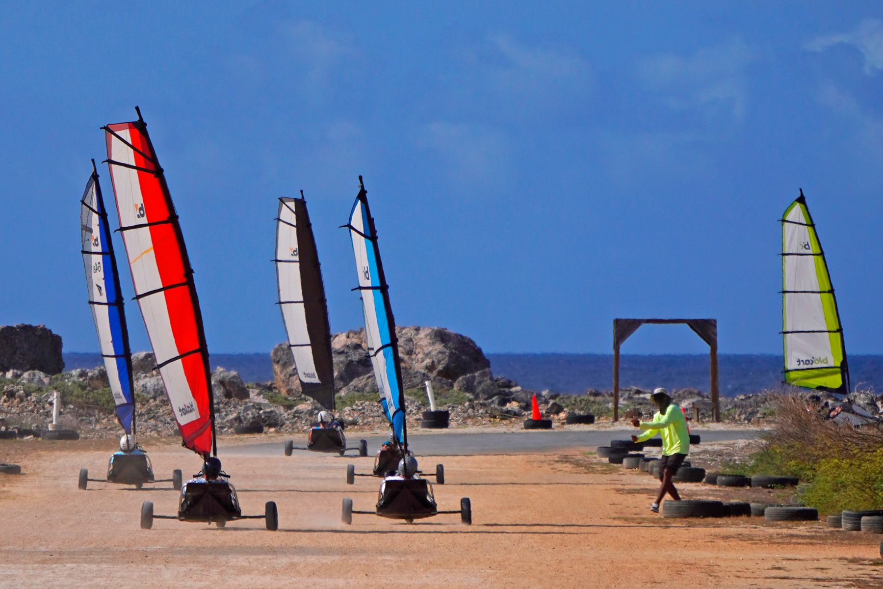 Three blokarts lined up by the sea